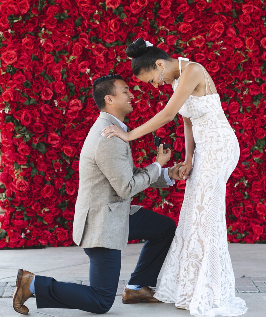 Red Flower Wall for rent with man proposing to a women